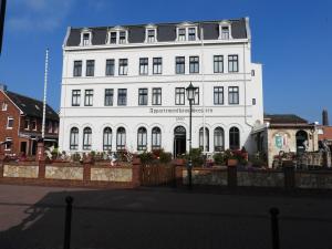 a large white building with a black roof at Appartementhaus Seestern in Borkum