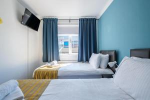 a hotel room with two beds and a window at The Douglas - Spacious 2 bed apartment in Uddingston in Uddingston