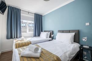 a bedroom with two beds and a window at The Douglas - Spacious 2 bed apartment in Uddingston in Uddingston