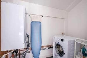a blue object in a laundry room next to a washing machine at The Douglas - Spacious 2 bed apartment in Uddingston in Uddingston +20 photos