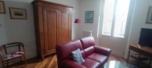 a living room with a red leather couch and a cabinet at Suite IN PIAZZA in Poggio Renatico +6 photos
