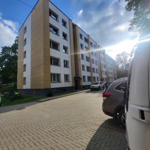 a large building with cars parked in front of it at Central Apartament in Telšiai