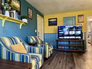 a living room with two couches and a flat screen tv at Afternoon checkout in Moorhead
