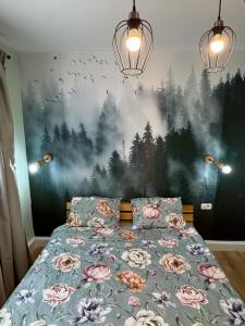 a bedroom with a bed with a painting on the wall at Apartament Tudor in Făgăraş