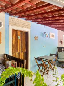a room with a table and chairs and a wooden door at Pousada Cantinho do Dodó in Mulungu