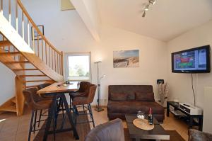 a living room with a couch and a table at Bella Casa 42 - SternenMeer in Juliusruh