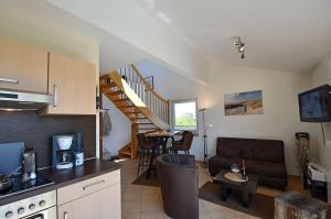 a kitchen and living room with a couch and a table at Bella Casa 42 - SternenMeer in Juliusruh
