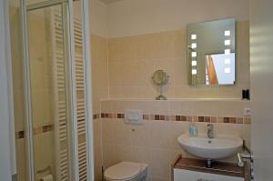 a bathroom with a sink and a toilet and a mirror at Bella Casa 42 - SternenMeer in Juliusruh +13 photos