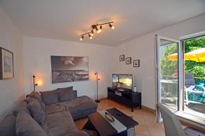 a living room with a couch and a tv at Bella Casa 34 - Strandblick in Juliusruh