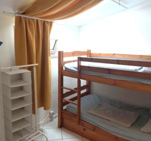 a room with two bunk beds and a curtain at Les canaris in Mimizan-Plage