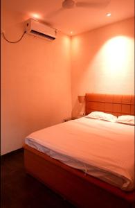 a bedroom with a bed with a light on the wall at Mount Magica - Refined By Nature in Rānchī