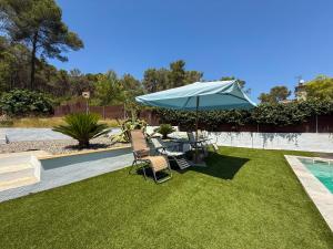 a patio with a table and chairs and an umbrella at Villa Claudia by Hello Homes Sitges in Sitges