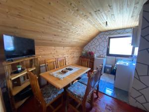 a dining room with a wooden table and a television at Woden apartment in Žabljak