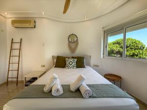 a bedroom with a large bed with a window at Villa Claudia by Hello Homes Sitges in Sitges +28 photos