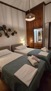 two beds in a hotel room with towels on them at Villa ChrysPa Attica in Dhílesi +45 photos