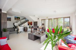 a living room with red furniture and a staircase at Chianti Village - Free Parking & Pool in Tavarnelle Val di Pesa