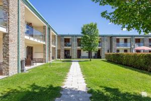 an exterior view of a building with a grass yard at Chianti Village - Free Parking & Pool in Tavarnelle Val di Pesa +169 photos