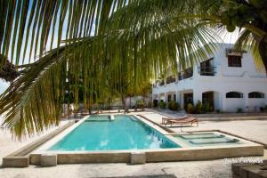 ein Swimmingpool vor einem Haus mit einer Palme in der Unterkunft Moonshine Uroa Boutique Hotel in Uroa