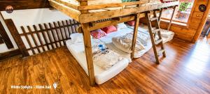 two bunk beds in a room with wooden floors at Vilimu Sodyba - Stone Hall in Kriukai +7 photos