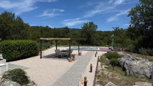 a patio with a chair and a pool at Private Villa Bonaventura with Pool & Jacuzzi & BBQ for Families & Groups near Split in Donja Mala