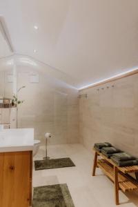 a bathroom with a sink and a bench with towels at Chalet im Obstgarten in Lengau +60 photos