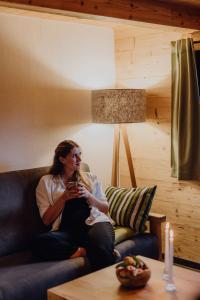 a woman sitting on a couch in a living room at Chalet im Obstgarten in Lengau