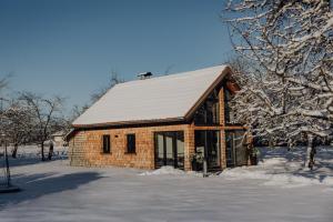 a small brick building with a snow covered roof at Chalet im Obstgarten in Lengau