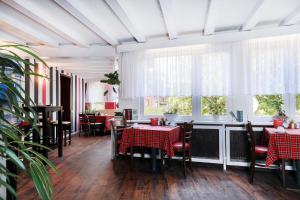 a dining room with tables and chairs and windows at Hotel Schloßschenke in Idar-Oberstein