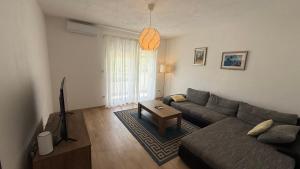 a living room with a couch and a tv at Private Villa Bonaventura with Pool & Jacuzzi & BBQ for Families & Groups near Split in Donja Mala