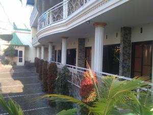 a building with a balcony on the side of it at Griya Imafa Inn Batu in Tlekung
