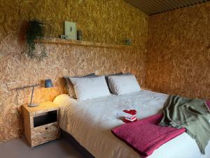 a bedroom with a bed with a red towel on it at The Grasshouse Cabins in Burrawang