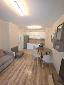 a living room with a couch and a table and chairs at Mountain View Apartment in Sofia