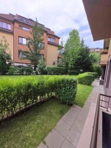 a building with a hedge in front of a yard at Mountain View Apartment in Sofia