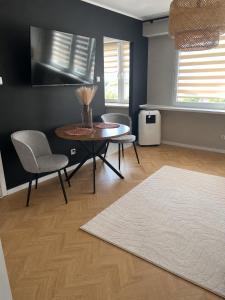 a living room with a table and chairs and a rug at Modern Apartament Zakole in Konin