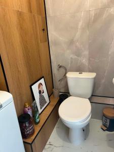 a bathroom with a toilet and a picture on a counter at Modern Apartament Zakole in Konin