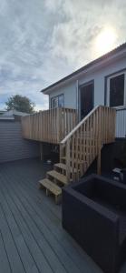 a deck with a wooden staircase next to a house at Gunnlaugsgata in Borgarnes
