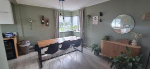 a dining room with a table and chairs and a mirror at Gunnlaugsgata in Borgarnes