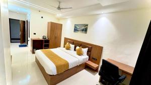 a bedroom with a bed and a desk and a television at Hotel Parv Vilas in Behror