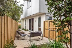 a backyard patio with two chairs and a fence at The Cape Collective 6 in Margaret River Town