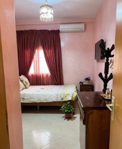 a small bedroom with a bed and a window at مراكش تامنصورت in Aït Ali