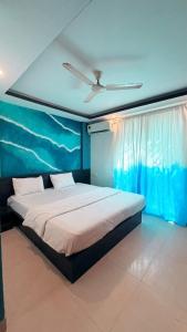 a bedroom with a large bed with a blue wall at Hotel Simba by Hakuna in Arambol
