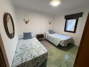 a room with two beds and a mirror at Casa Cueva Toni in Alcalá del Júcar