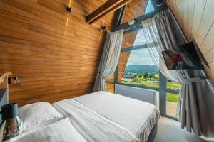 a bedroom with a bed and a large window at Pensiunea La Bella Vista in Poiana Negrii