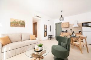 a living room with a couch and chairs and a kitchen at Ampeli Residences-Sea view-Private Pool in Zipárion +50 photos