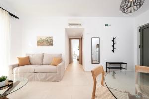 a white living room with a couch and a table at Ampeli Residences-Sea view-Private Pool in Zipárion