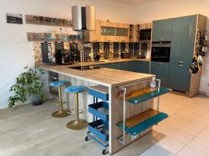 a kitchen with a island with blue bar stools at Haus Güldengossa in Großpösna