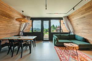 a living room with a green couch and a table at Pensiunea La Bella Vista in Poiana Negrii
