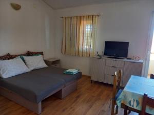 a bedroom with a bed and a flat screen tv at Hilly house - Vis in Vis