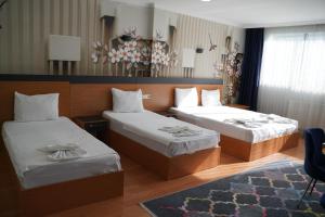 a hotel room with two beds and a rug at Heraldic Room Hotel in Esenyurt