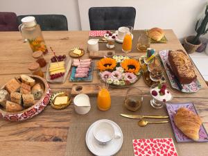 a wooden table topped with food and orange juice at Chez Céline in Cherbourg en Cotentin